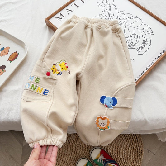 Beige children's pants with colorful patches on a light background